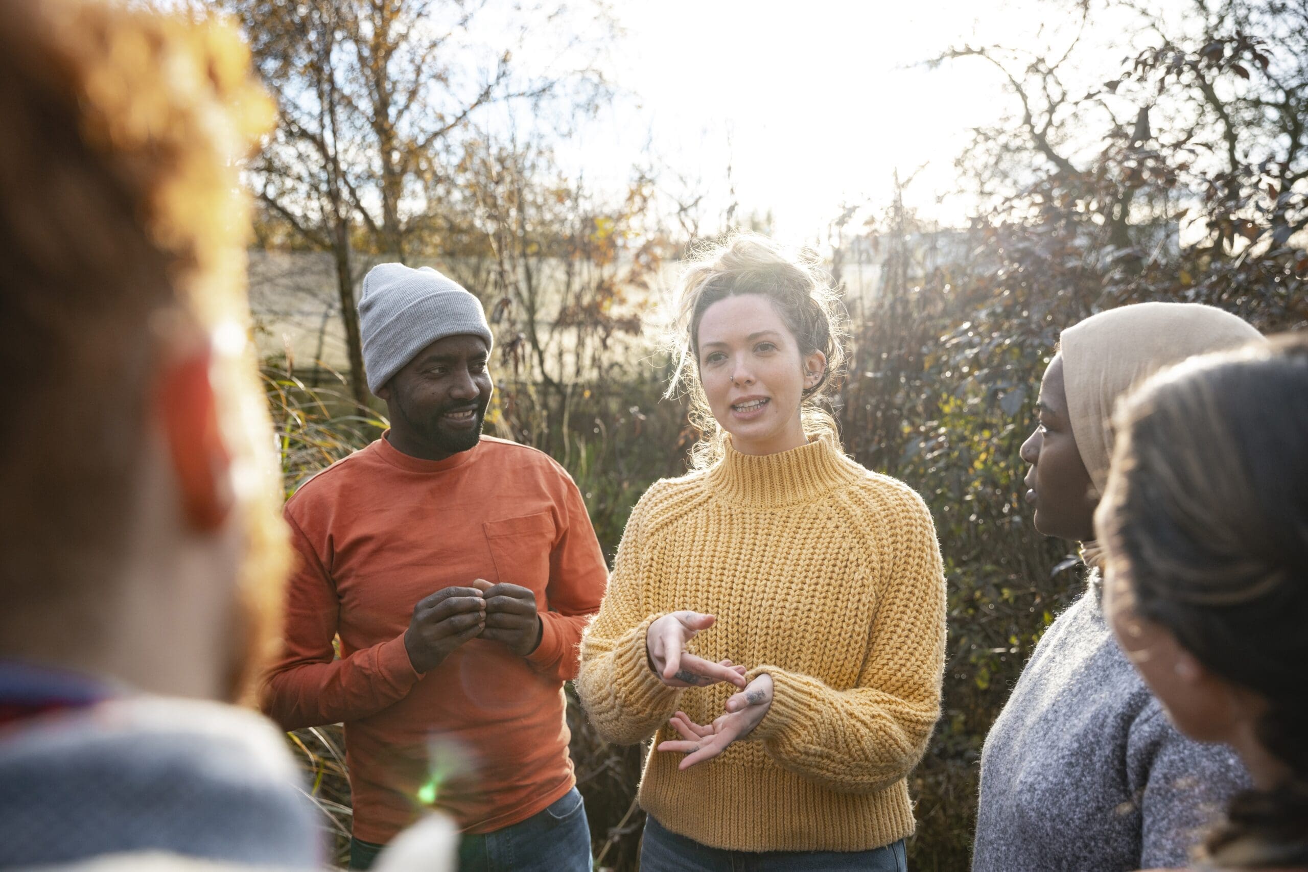 A woman leads a group of nonprofit volunteers in an outdoor space