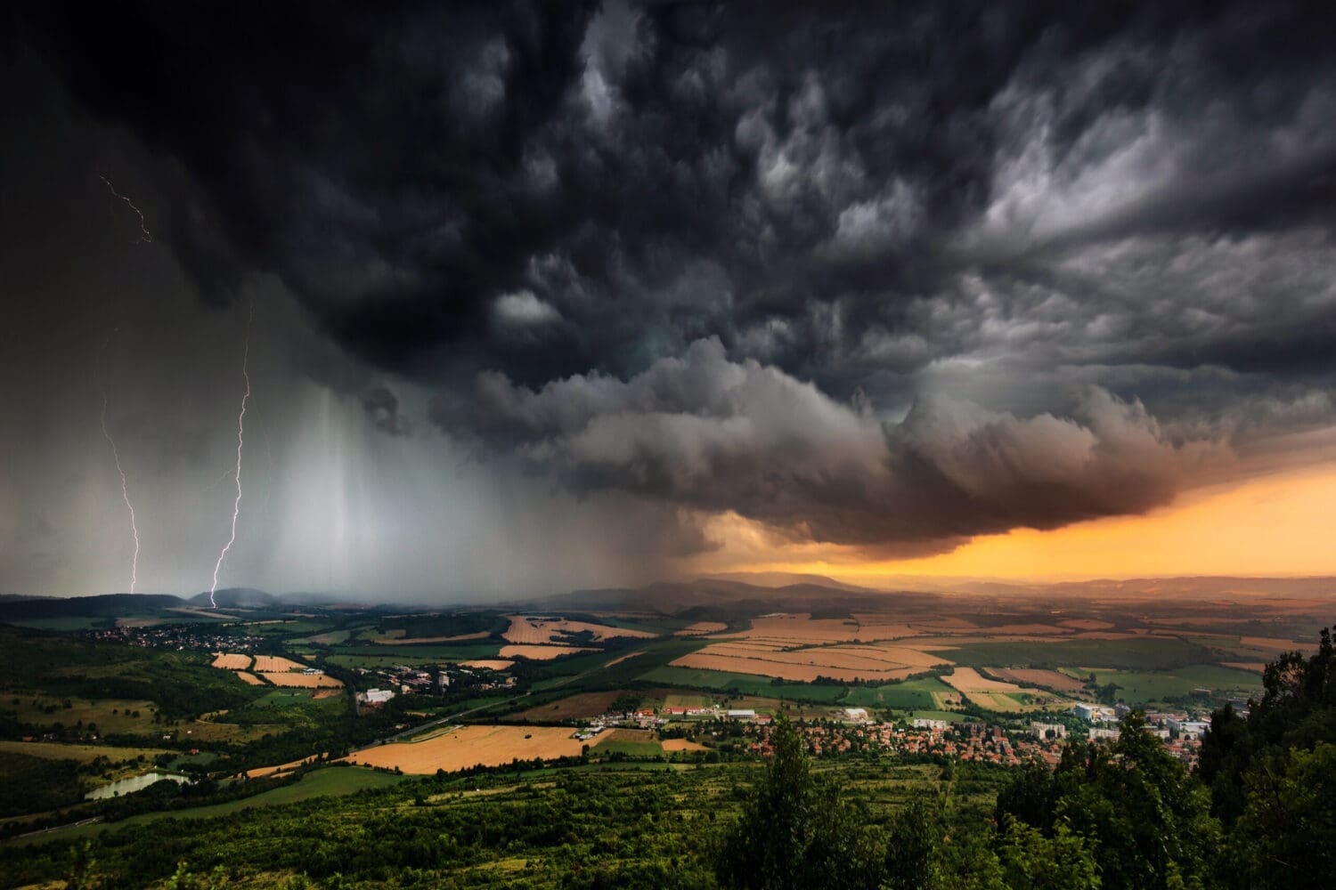 A severe thunderstorm shelf cloud races across the country side on a summer afternoon