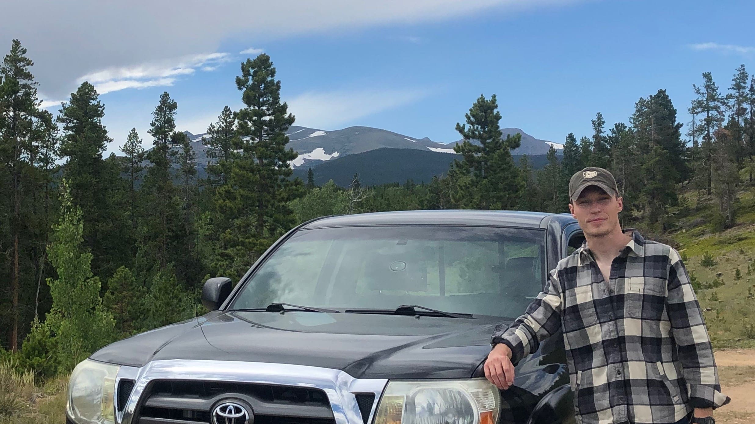 Noah Washko, an Environmental Policy and Management student, poses in the mountains of Colorado next to a pickup